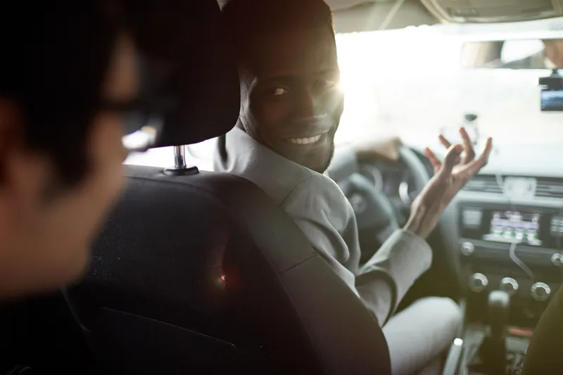 an uber driver talking to his client and not paying attention to the road