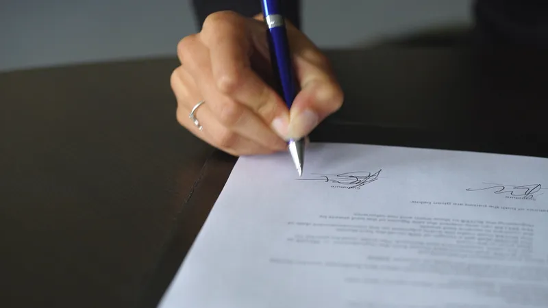 A lawyer signing a document, representing the formal nature of demand letters