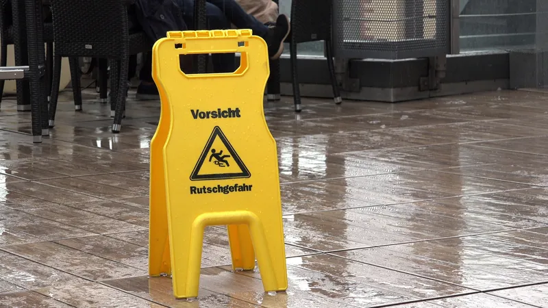 a wet floor with a warning sign